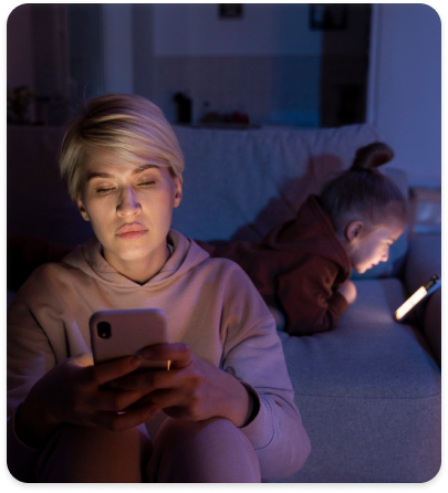 Personne assise dans une chambre, téléphone en main